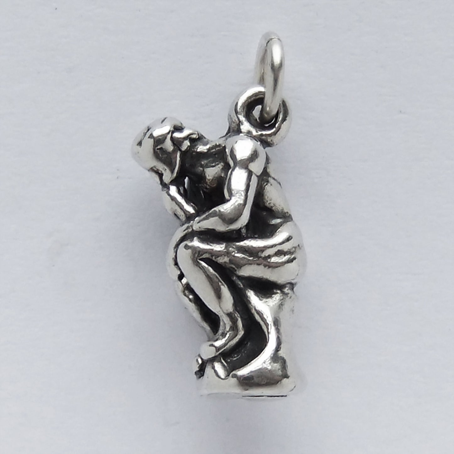silver the thinker sculpture charm on light grey background