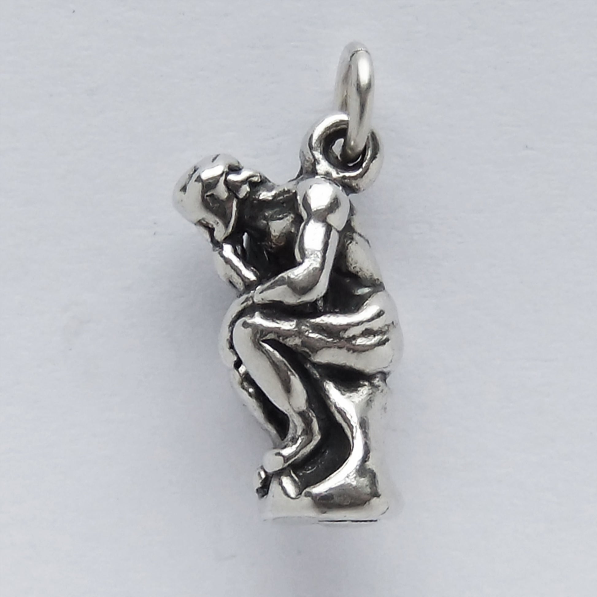 silver the thinker sculpture charm on light grey background